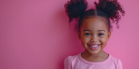 Fototapeta premium Portrait of a little curly African American girl on a pink background with copy space
