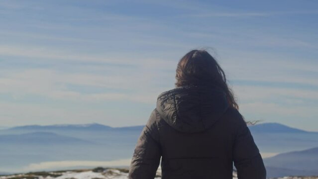 Mujer admirando el paisaje de Stara Planina en el pico de la montana de espalda a ella