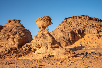 Tadrart landscape in the Sahara desert, Algeria. This red sandstone rock was sculpted by the wind and appears to represent a hedgehog on its pedestal - 732661052