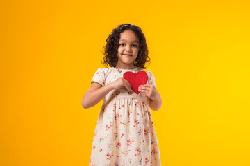 Child girl holding paper heart. Love, care and Valentine day concept