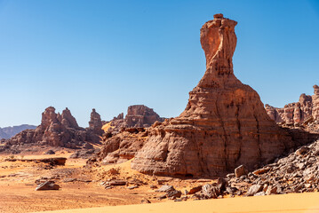 Landscape of the Red Tadrart in the Sahara Desert, Algeria. A sandstone peak reminiscent of the football World Cup trophy - 732665097
