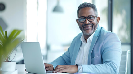 A professional in a light blue blazer is working on a laptop at a modern office desk, exuding confidence and satisfaction with their work.