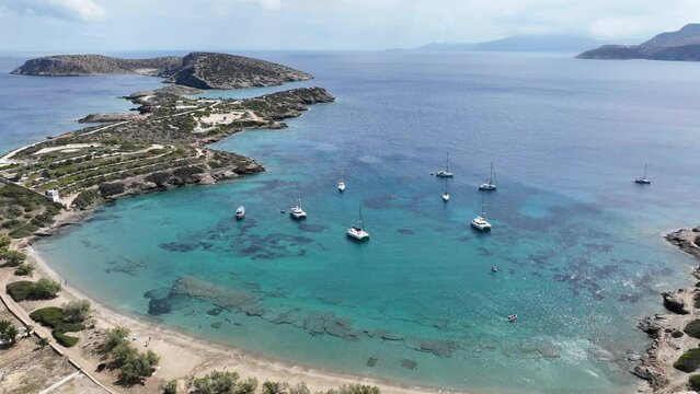 Aerial drone video of paradise beach of Livadi visited by yachts and sail boats in island of Schoinousa, Small Cyclades, Greece