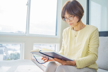 窓際で読書する女性