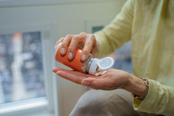 ボトルから薬を出す女性