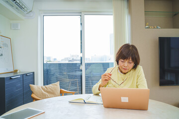 パソコンで仕事するシニア女性
