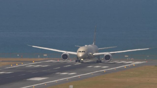 Wide body airliner departure at Phuket Airport. Airplane on the runway, sea background