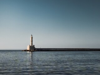 Fototapeta premium Lighthouse in the city of Chania in Crete, a beautiful bay overlooking the Mediterranean Sea. Beautiful sunrise and a spectacular lighthouse