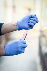 In the hands of a test tube with blood for analysis of the virus. Covid-19 is a danger to the...