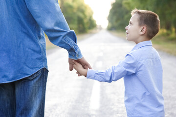 A Happy parent with a child in the park hands on nature travel go along the road