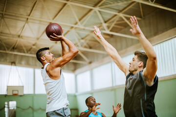 Young people playing basketball in an indoor basketball gym