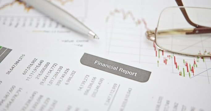 Blue pen atop quarterly corporate financial report&mdash;anticipating analysis by financial and investment expert prior to public disclosure. Illustrating financial analysis and investment insight concept.