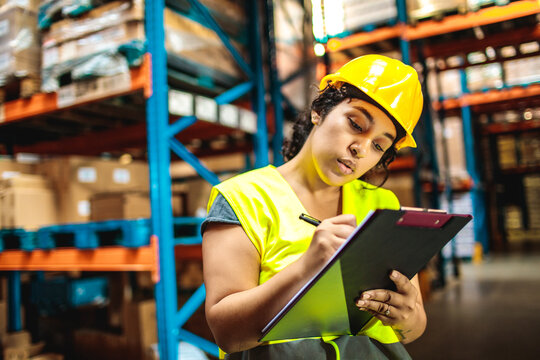 Young woman warehouse supervisor with clipboard