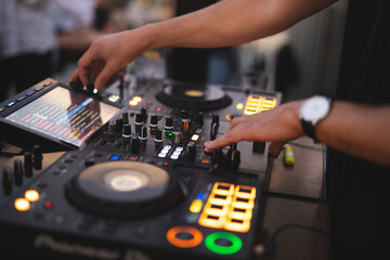 Obraz premium a DJ plays music on a controller at a party