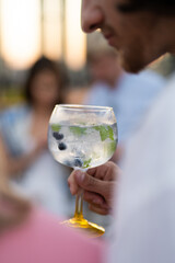 holding cool fresh alcoholic cocktail in hands at party