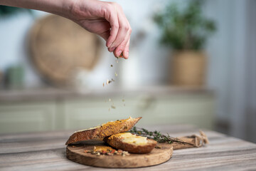 pour seasoning on a sandwich with butter on a wooden board