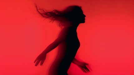 Woman blurred silhouette on a red background. Elegant outline of a woman in motion out of focus
