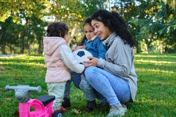 Dominican mother easing sibling rivalry teaching her kids to share the soccer ball.