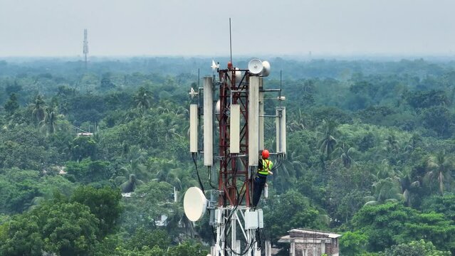 Technician climbing a network tower to fix it. Skilled work that technicians do to keep our communication networks running smoothly