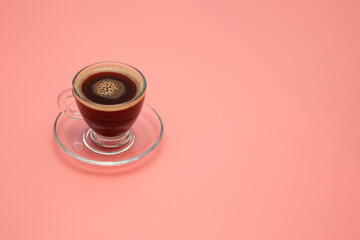 cup of coffee on pink surface with copy space