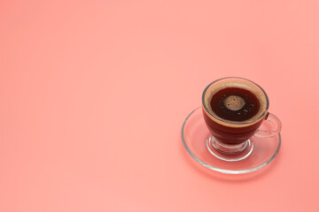 cup of coffee on pink surface with copy space
