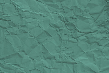 Background of crumpled turquoise paper, providing a vibrant and textured visual perfect for creative backgrounds
