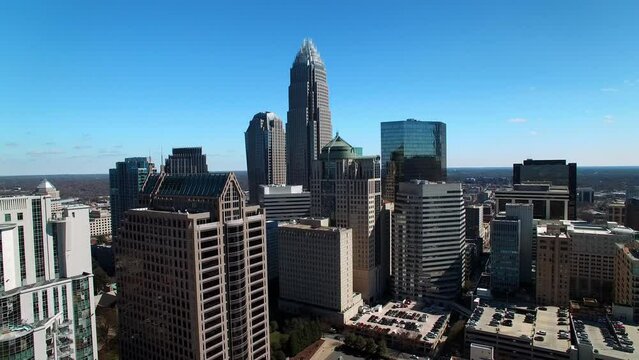 Aerial Shot Of Office Buildings In Financial District Against Sky, Drone Flying Backwards On Sunny Day - Charlotte, North Carolina