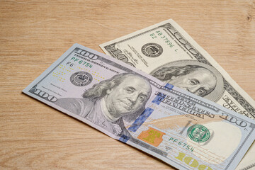 New and old 100 dollar banknotes on wooden floor. Side view. Metaphor for economic renewal. Reserve currency concept idea.