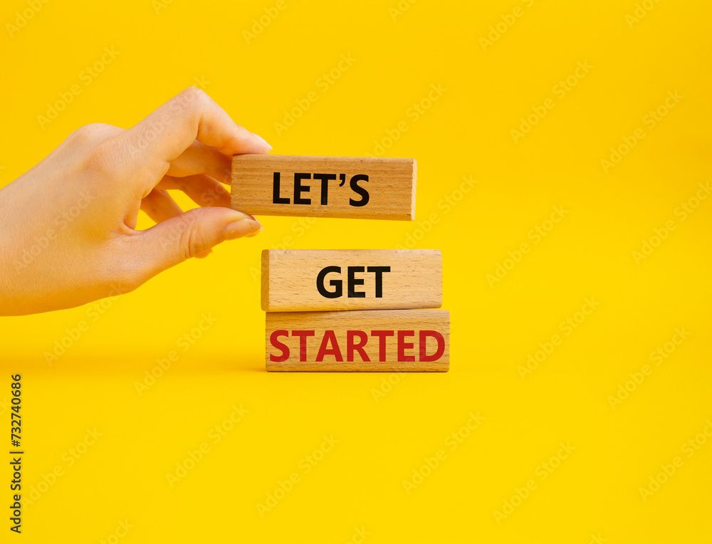 Wall mural lets get started symbol. concept words lets get started on wooden blocks. beautiful yellow backgroun