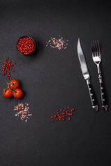 Salt, allspice, cherry tomatoes with copy space on a dark concrete background