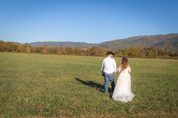 Naklejka premium Country couple field stroll to mountains