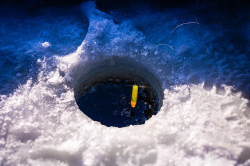High Angle Shot of a Bobber in an Ice Fishing Hole