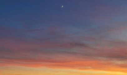 La Luna al tramonto nel cielo blu e arancione  - obrazy, fototapety, plakaty
