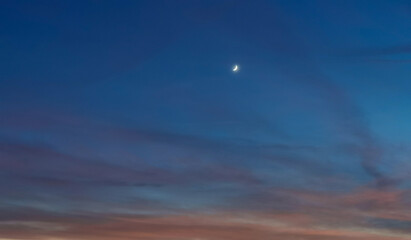 La Luna al tramonto nel cielo tra notte e giorno
