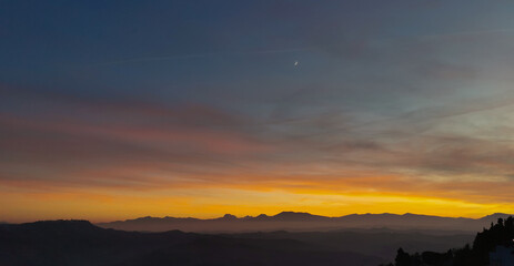 qrf Tramonto cobalto e arancio con luna nel cielo sopra le valli e le montagne
