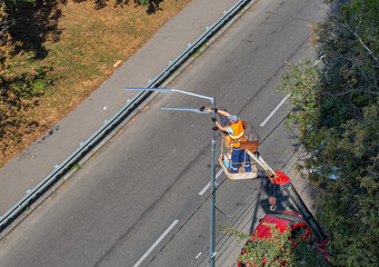 Workers installing a new street lamp.