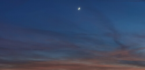 Fototapeta na wymiar La Luna al tramonto nel cielo tra notte e giorno