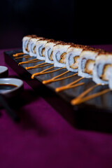 Crab Ebi Uramaki served on a black wooden plate, avocado, cucumber, lump crab meat, sushi menu, social media post, food photography, fine dining, Japanese food, purple background