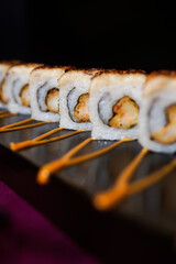 Crab Ebi Uramaki served on a black wooden plate, avocado, cucumber, lump crab meat, sushi menu, social media post, food photography, fine dining, Japanese food, purple background