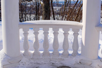 a fragment of a white gazebo in a snow-covered park