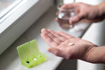 close up of male hands holding capsule pill and glass of water. Medicine pharmacy health. close up...