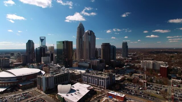 Aerial Panning Shot Of Spectrum Center Arena By Modern Buildings In Downtown District, Drone Flying On Sunny Day - Charlotte, North Carolina