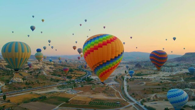Aerial video. Captured against the canvas of the Cappadocian sky, this video showcases the enchanting spectacle of a hot air balloon festival. The vibrant balloons rise gracefully over the valleys of