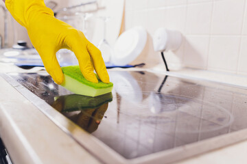 Cleaning kitchen hob with a steam cleaner.
