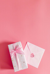 One gift box with an envelope on a pink background.