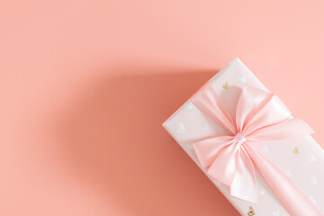 One gift box with a bow on a pink background.