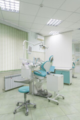 Metal dental chair in blue and white color inside the dental office