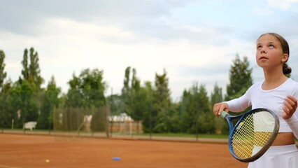 Focused girl tennis player holding racket and bouncing ball. professional tennis training, sport and competition concept, slow motion - Powered by Adobe