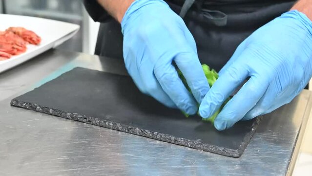 chef con i guanti prepara una insalata per una ricetta nella cucina del ristorante
