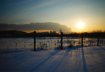 Fototapeta premium Sunset rays coming though fence urban landscape
